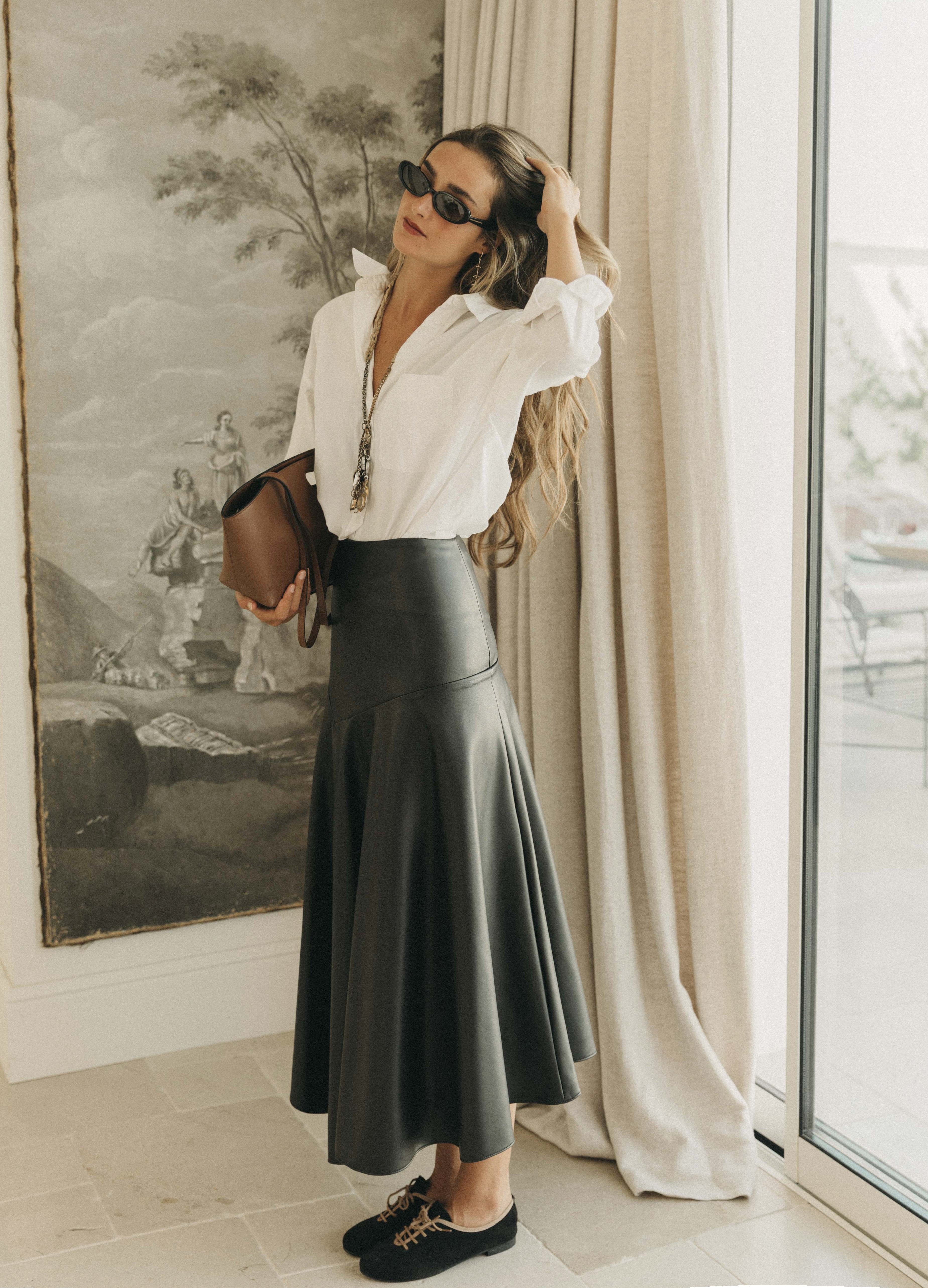 Falda Hollaway negra combinada con camisa blanca y bolso