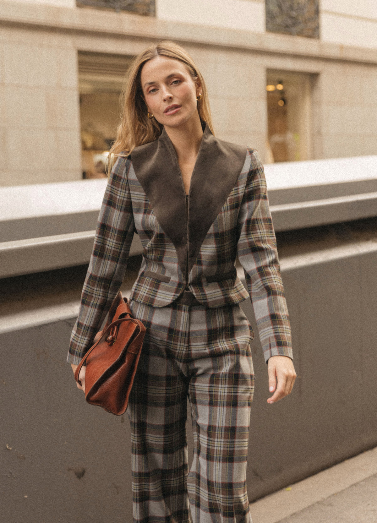 Look completo de chaqueta corta y pantalón de cuadros topo, con bolso cognac