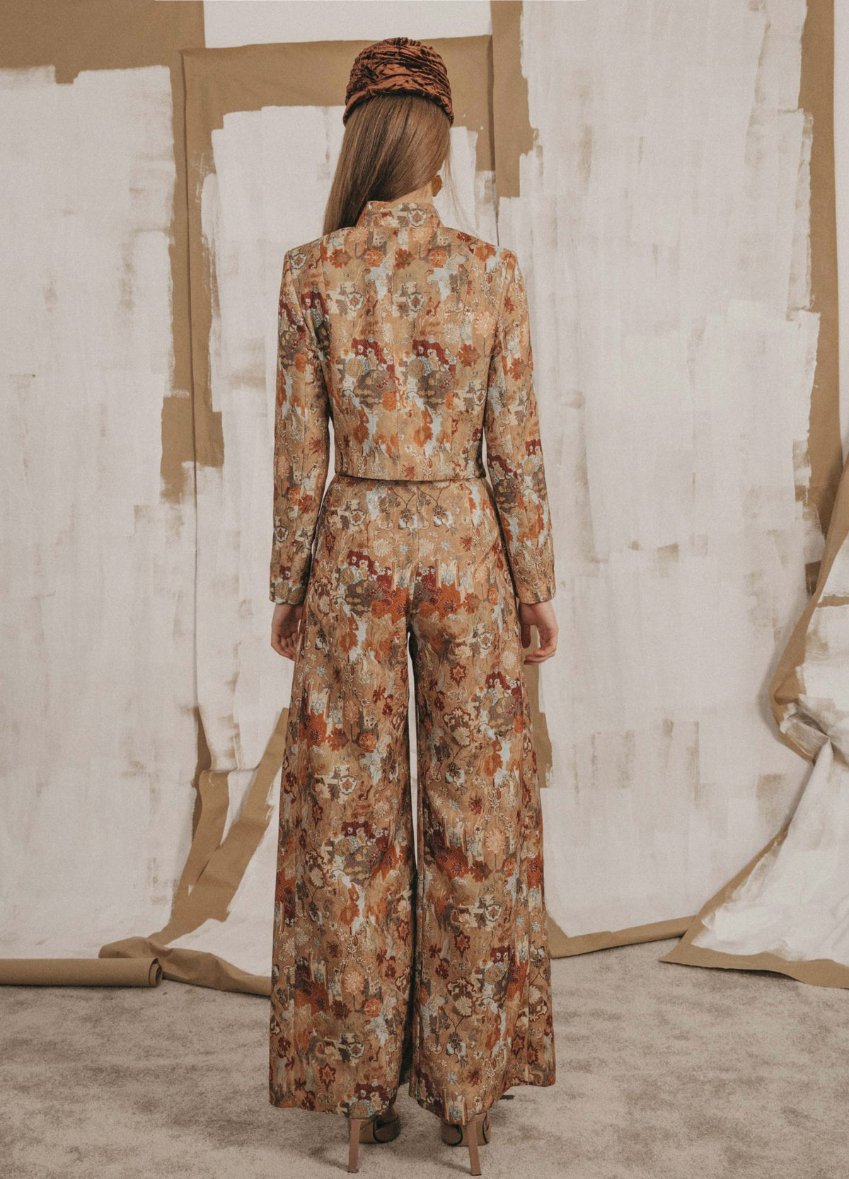 Pantalón palazzo Pembroke beige, vista de espalda con pernera ancha hasta el suelo | Cherubina