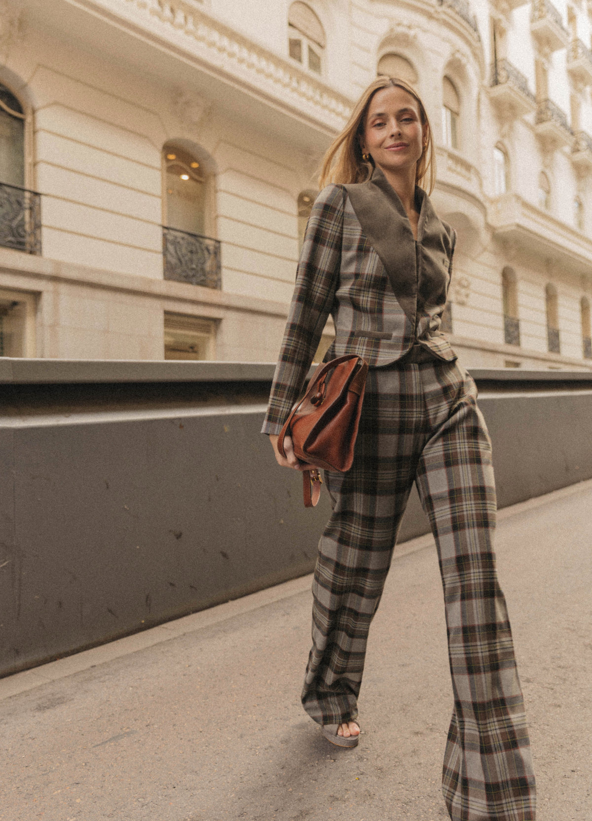Look con chaqueta corta y pantalón de cuadros topo de pernera ancha, con bolso cognac